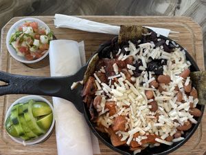 Nopal Montado - cactus with jamaica (hibiscus flowers), jackfruit, mushrooms, rice and whole beans - topped with vegan cheese and served with salsa, cucumbers and tortillas  at Taqueria La Esquina in Tucson