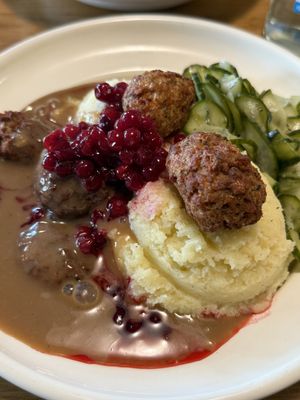 Two large scoops of mashed potatoes, cucumber salad, vegan meatballs, gravy sauce, and cranberry sauce  at Möllers Köttbullar - Danziger Str. in Berlin