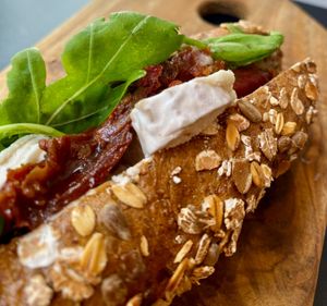 Cereals baguette with cashew brie, dried tomatoes and rocket at Fermaggio Bistrot & Store in Rome