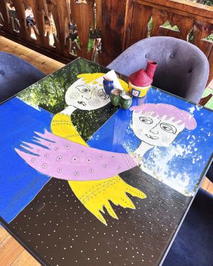 The surfaces of the tables are glass, under which there are real paintings by famous artists! at Machanents House — Մաչանենց տուն in Vagharshapat