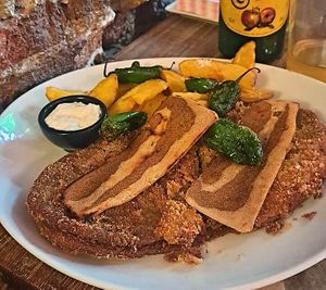 Cachopo vegano con bacon plant based, patatas y pimientos de Padrón at Con 2 Fogones in Madrid