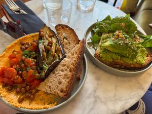 Aubergine and humous plate with crunchy chickpeas and avocado and pea purée toast. at Maison Fleuret in Paris