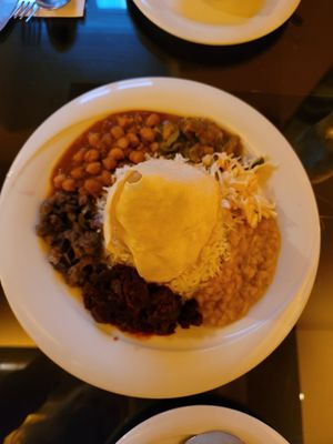 Middle plate contains 5-curry dish with papadam tent and rice in the middle. Two dishes of dahl on the outside plates at Curry Insel in Vienna