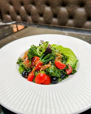 The Fellows Salad: a vibrant medley of quinoa, avocado, pomegranate, and roasted vegetables, all tossed in a zesty citrus dressing. at The Folio Bar & Kitchen  in Cambridge