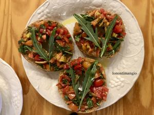 Bruschetta with tomatoes and rucola and olive oil all produced by us  at Home Restaurant Ionontimangio in Sassari