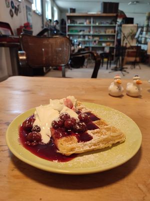 Vegan waffle with hot cherries, whipped cream and vanilla ice cream at Café Mau Mau in Nideggen