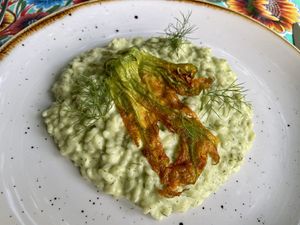 S. Andrea semi-finished rice risotto from the Marta Sample farm with fermented cashew cream, aromatic herbs, fermented lemon and courgette flowers  at La Cena di Pitagora in Ponte Nizza