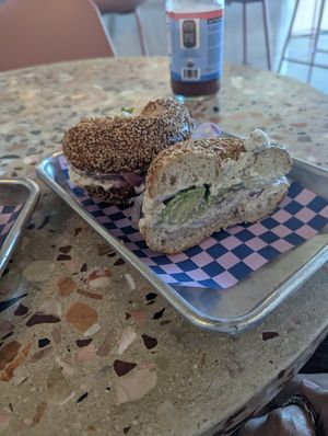 toasted sesame seed bagel with vegan cream cheese onions (raw and pickled) radish and avocado at Flour Moon Bagels in New Orleans