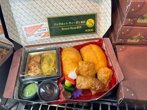 Box featuring seitan three ways and rolls to assemble sandwiches. Pea puree and BBQ sauce on the side. at The Making of Harry Potter - Backlot Cafe  in Tokyo