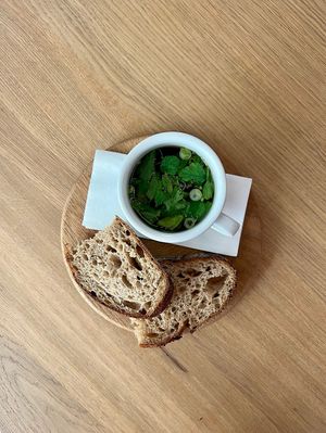 vegetable broth in a mug with sourdough bread at Anežka in Prague