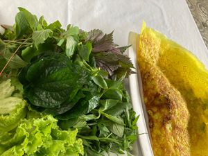 Bánh Xèo with huge pile of herbs, also some dipping condiments, peanuts, $4, could share between 2. at Magnolia Veggie Restaurant in Phnom Penh