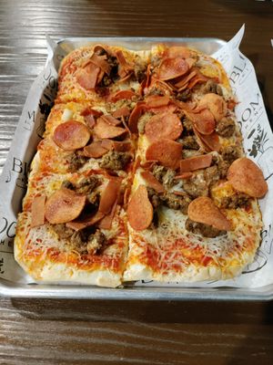 Meat lovers pizza with generous toppings at Bloom Kitchen & Co in Oxford