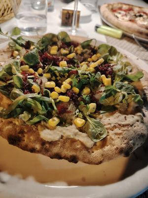 Vegan pizza with sweet onion, sweetcorn, beetroot on hummus base  at La Nuova Campana in Castellammare Del Golfo