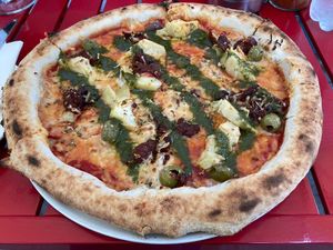 Vegan pizza with artichokes, dried tomatoes, olives and pesto  at Bar Flama in Santiago