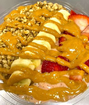Peanut Butter Acai Bowl! It's a delicious blend of organic acai, crunchy granola, cacao nibs, banana, and a drizzle of peanut butter. at Taste Haven Healthy Cafe & Meal Prep in Seaford