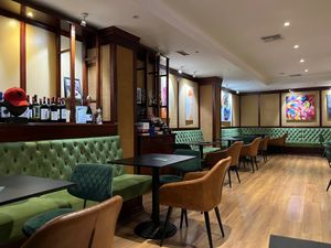 Interior dining area with plush green benches at Bitter in Tirana