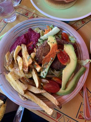 Vegan burger plate with beet hummus, fries, salad, and avocado  at Tranquilo in Santorini