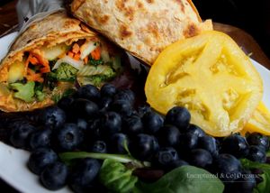 Hearty Summertime Veggie Wrap! Toasty Sundried Tomato Wrap with Sundried Tomatoes, Garlic Hummus, Grilled Zucchini, Cabbage, Kale and Broccoli, Marinated Cucumber and Garden Tomato Salad!  at Sprouts Cafe in Gastonia