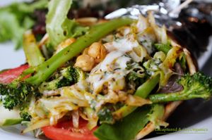 Green Veggie and Chickpea Pita! Seasoned, grilled organic green veggies and chickpeas on a warmed pita with fresh made basil hemp seed pesto, melty mozzarella cheese, fresh mixed greens and marinated tomato cucumber salad!  at Sprouts Cafe in Gastonia