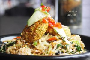 Tofu Veggie Cakes over a Szechuan Rice and Veggie Stir Fry! Our Tofu Cakes made with organic veggies, chickpeas, chia, extra firm tofu, nutritional yeast, and a fusion of Indian and Asian spices served over stir fried veggies & brown rice.  at Sprouts Cafe in Gastonia