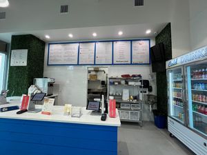 Cute interior with bar height seating on the inside and additional tables outside. Vegan options listed with a V. at Pacific Counter  in Tampa