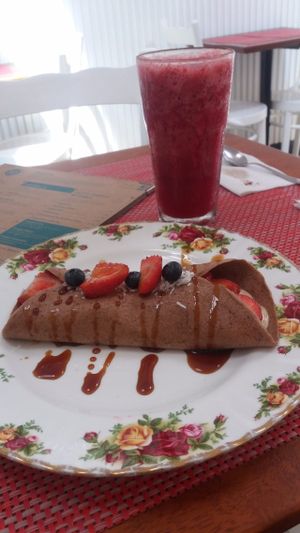 Pancakes with vanilla cashew cream, fruits, agave syrup and coconut flakes at Raw Cafe in Lima