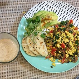 Scrambled tofu with tomatoes, mushrooms, spinach, avocado & corn bread. at Raw Cafe in Lima
