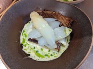 White asparagus on a cheesecake paired with smoked mushrooms and a white wine sauce with cherville oil  (vegan) at Cochon&Carot in Hemiksem