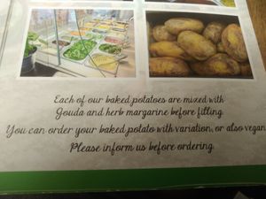 The fine print for vegans. Portions by default have cheese (gouda) in them. at Erdapfel in Luebeck