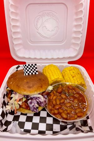 BBQ Pulled Chickun with mango creamy coleslaw on bun, and spicy baked beans and cajun corn.  at Feed Me in Amarillo