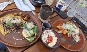 You’re seeing half a plate of avocado toast and tlayuda, an açaí bowl and a plate of chilaquiles   at Antigua Coffee & Bakery in San Jose Del Cabo