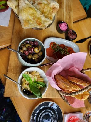 Bread basket, garlic bread, beetroot hummus, tapenade, vegan cuts, artichokes, and olives at Ravintola Daisy in Tampere