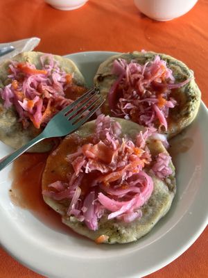 A Spinach, a pumpkin, and a black been Pupusa each topped with curtido and habanero salsaa  at Waruguma in San Pedro