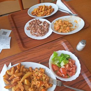 Potato wedges, bean salad, đuveđ, fresh green and tomato salad. at Restoran Markat in Pula