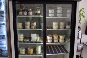 Fridge of items at TBC! Salsa, cheeze sauce, queso dip, eggy salad, tofu scramble, soyrizo, seitans, fermented veggies, soups, Ceasar dressing, and Ladyship vegan cheeses (they're sooo good).  at Through Being Cool Vegan Baking Co. in Toronto