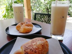 Latte frío, nudo de ajo y pan agridulce con arequipe de coco at Cósmico Restaurante in Cundinamarca