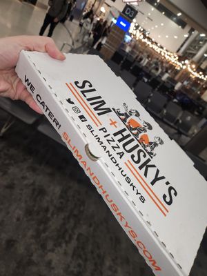 The pizzas are oval shaped at BNA - Slim & Huskie's - Concourse C in Nashville