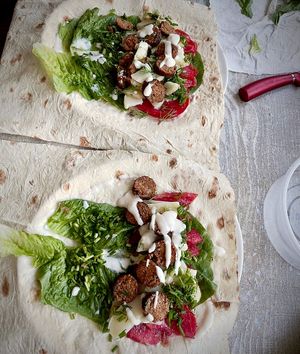 Making wraps with Kruzhok's fried vegan sausages, lettuce, tomatoes and homemade cashew sauce at Kruzhok in Yerevan