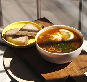 Solyanka: vegetable broth, potatoes, homemade sausages, pickled cucumber, champignons, carrots, onions, herbs, olives, cashew aioli, lemon at Kruzhok in Yerevan