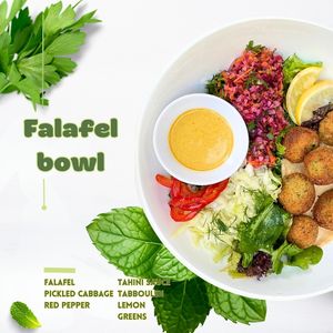 Falafel is served with greens, pickled cabbage, red pepper, tahini sauce, lemon, and tabbouleh. at Sisu Kitchen %100 Vegan in Antalya