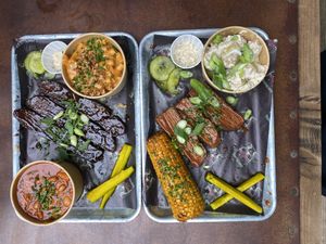 Rib and brisket trays with Mac and cheese, baked beans, corn on cob and potato salad.   at Saint Monday in East London