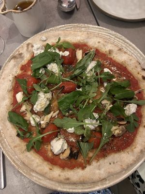 Pizza with vegan cheese, cherry tomatoes, and arugula   at Masa Madre in Paris