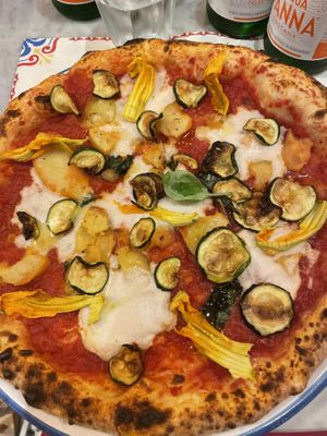 Pizza with tomato, vegan cheese, zucchini, roasted potatoes and pumpkin flowers  at Pizzium in Verona