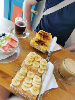 Toasts with peanut butter/banana and hummus, granola with vegan milk and fresh fruits at Kiwi Kafé in Salento