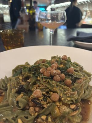 Kale infused mafaldine pasta, zucchini, squash, peas, mushroom confit, pistachio, crispy chick peas, basil oil  at  Testa Barra Kitchen & Cocktails in Macomb Township