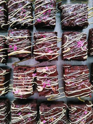 Dark Chocolate Brownies with Passionfruit Chocolate Drizzle, rose petals and edible 24k gold at The Edible Journey in Port Stanley