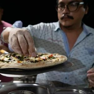 Topping the Fresh Arrugula post Baking at Itza Pizza in Santa Cruz