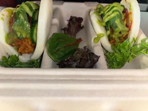 (2) steamed bao buns stuffed with a red curry jackfruit topped with fresh cucumbers, pickled red onions/ginger, fresh basil and drizzled with cilantro lime sauce. at Hidden Leaf Cafe in Columbus