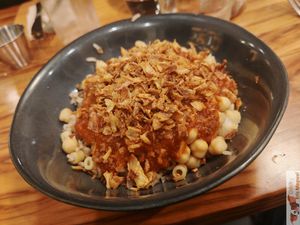Kochari: Mixture of rice, pasta, brown lentils, chickpeas, tomato sauce and fried onions at Veganil in Paris