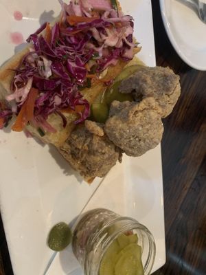 The vegan fried chicken sandwich and a side pickle jar  at Postbellum in Richmond